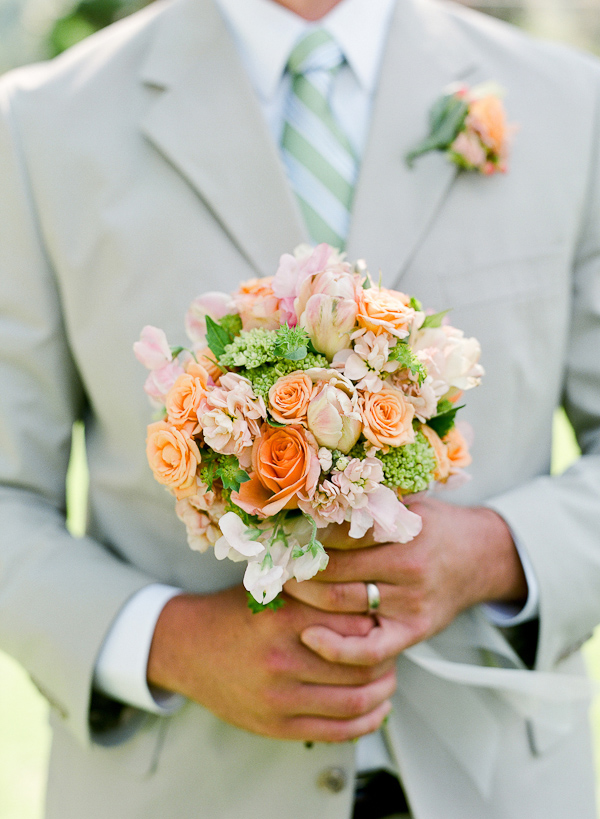 groom in light gray suit, holding light pink and orange bridal bouquet - photo by San Francisco based wedding photographer Lisa Lefkowitz